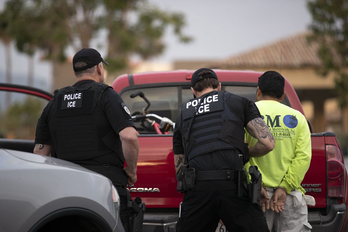 In this July 8, 2019 photo, U.S. Immigration and Customs Enforcement (ICE) officers detain a man during an operation in Escondido, Calif. During the Trump administration