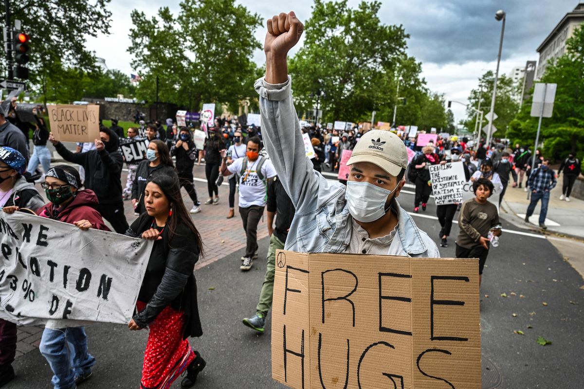 Dashea McDowell offers free hugs as thousands protesters in support of Black Lives Matter, leave Riverfront Park on their way to march across the Monroe Street Bridge, Sunday, June 7, 2020, in downtown Spokane. McDowell said,”Love is a gift, hate is a burden.” (Colin Mulvany / The Spokesman-Review)