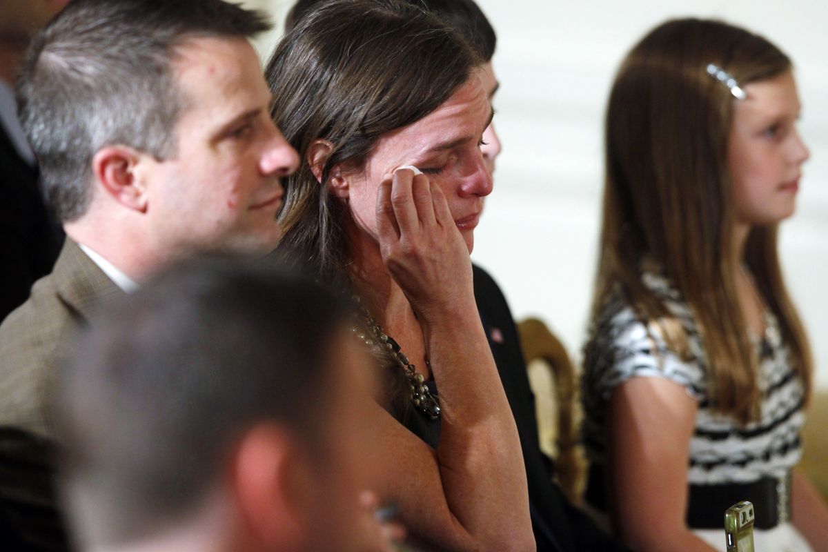 An unidentified audience member wipes her eye as President Barack Obama speaks about the gallantry of former Army Capt. William D. Swenson, of Seattle, on Tuesday. (Associated Press)