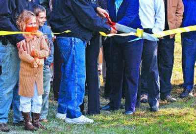 
Aspen Stam, 7, and her 8-year-old brother, Noah, watch as the ribbon is cut by City Councilman Ron Edinger, Mayor Sandi Bloem and Midge Smock at the groundbreaking for the Shasta Groene home in Coeur d'Alene on Tuesday.  Their father, Todd Stam, is with Aspen Homes, the contractor for the project. 
 (Liz Kishimoto / The Spokesman-Review)