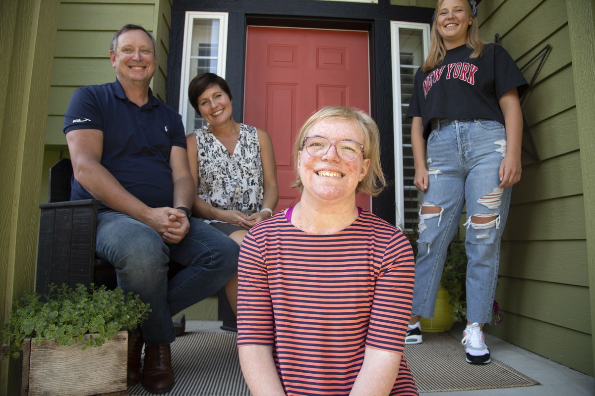 Grace Carney, 18, foreground, sits with her parents, Chris and Janet, and sister, Gillian, at their Spokane home on July 31. Grace suffers from neurofibromatosis, a genetic disorder that causes tumors to grow all over the body, including one that had wrapped around her spine and caused pain and threat of paralysis. A new drug has shrunk her tumors instead of her having to face a dangerous, complex surgery. (Jesse Tinsley/The Spokesman-Review)