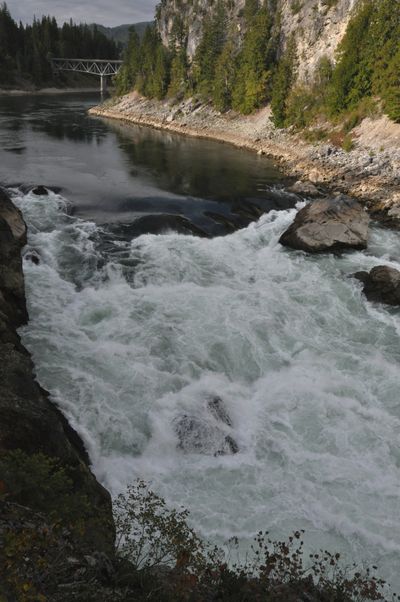 The Pend Oreille River powers through Metaline Falls on Sept. 11, 2010, during the maintenance drawdown of more than 30 feet on the reservoir behind Boundary Dam. This photo was captured from the cliff on the east side of the river near Deadman's Eddy.  The town of Metaline Falls and the State Highway 31 Bridge are in the background.