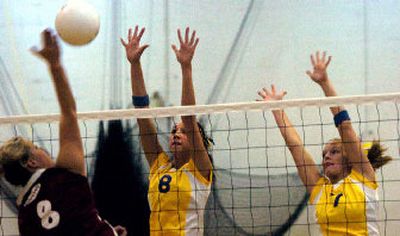 
Jayme Albrandt from Moses Lake High spikes the ball across the net to the waiting hands of Shannon Chan, center, and Jessica Stebbins from Mead. 
 (Amanda Smith / The Spokesman-Review)