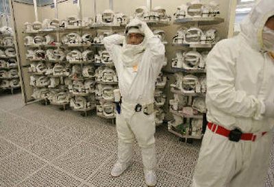 
Intel Corp. manufacturing technicians suit up before entering a clean room to produce Intel chips at Intel headquarters in Santa Clara, Calif., on Thursday. Adding to signs that the overall semiconductor industry is performing better than expected, Intel raised its second-quarter revenue forecast, citing higher demand for chips that power notebook computers.
 (Associated Press / The Spokesman-Review)