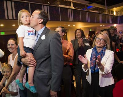 State Rep. Marcus Riccelli, who represents the 3rd Legislative District, kisses his daughter Bryn, 3, and 6th Legislative District candidate Lynnette Vehrs, on right, celebrates early results showing them leading their challengers, Tuesday, Aug. 2, 2016. (Colin Mulvany / The Spokesman-Review)