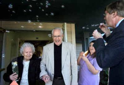 
Anna and Wayne Loomis, married 64 years, are greeted by bubbles Tuesday at Rockwood Retirement Communities on the South Hill after a party for couples married 60 years or longer.
 (Colin Mulvany / The Spokesman-Review)