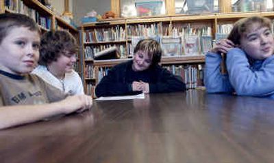 Sorensen Elementary School fifth-graders from left Nathan Guillet, Sam Fortis, Evan Smith and Jenny Brooks will help their teacher Dave Groth to finish a book about cancer. 
 (Kathy Plonka / The Spokesman-Review)