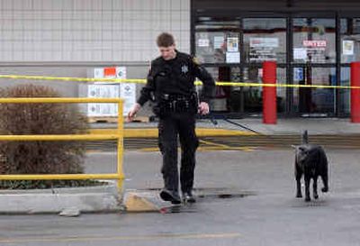 
Deputy J.P. Melton and his explosives-sniffing dog Logan head to their truck after searching the Safeway at Sprague and Evergreen  on Thursday. 
 (Liz Kishimoto / The Spokesman-Review)