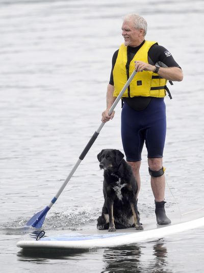 Mike Web and his dog Mango enjoy a stand-up paddle near Owen Beach in Tacoma last month. (Associated Press / The Spokesman-Review)