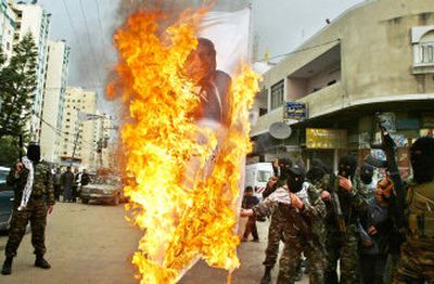 
 Palestinian gunmen burn a poster of Israeli Prime Minister Ariel Sharon during a protest in Gaza city on Monday. About 40 masked gunmen from the Al Aqsa Martyrs' Brigades militant group held the demonstration against Sharon. 
 (Associated Press / The Spokesman-Review)