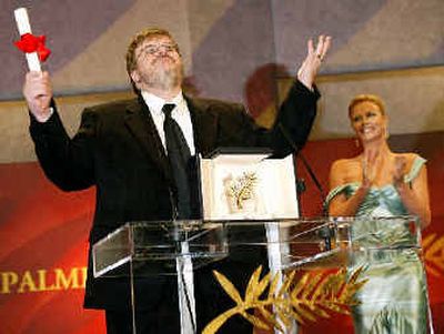 
Director Michael Moore reacts with the Palme d'Or as he is awarded the Palme d' Or for the film 