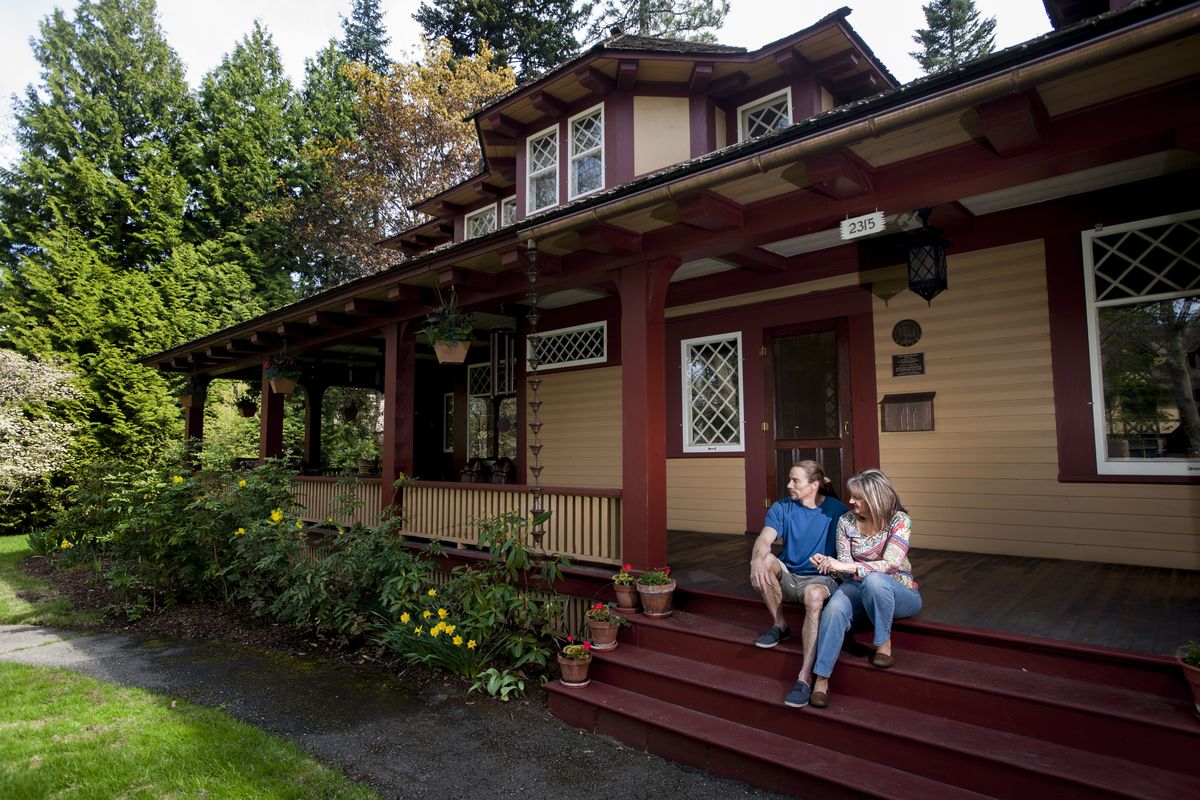 Rick and Julie Biggerstaff sit on the porch of their historic home, the Reid House, in Browne’s Addition. (Tyler Tjomsland)