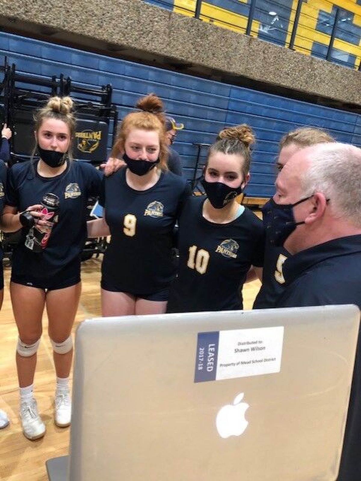 Mead volleyball coach Shawn Wilson, right, address his team in person and via Zoom during a timeout during a match against Central Valley last week.  (Courtesy of Heather Wilson)