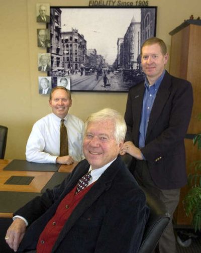 
Barry Jones, chairman of the board of Fidelity Associates, center, poses with President and CEO Scott Jones, left, and Vice President Craig Jones  for a portrait in front of a  photo of Spokane's Riverside Avenue circa 1909. 
 (Christopher Anderson / The Spokesman-Review)