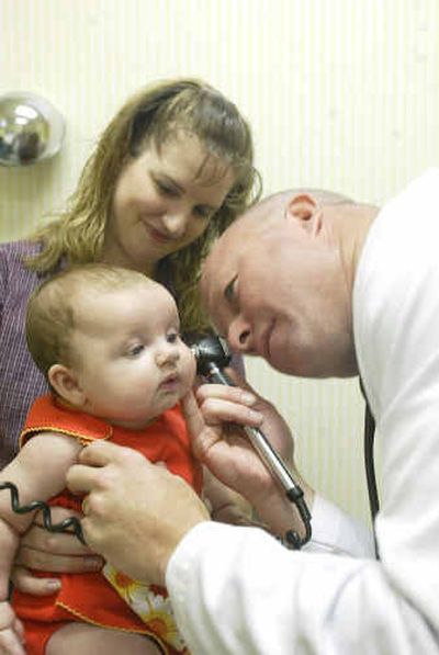 
Dr. Steve Peasley examines 4-month-old Kaylynn Heimsoth while her mother Tammy holds her in Peasley's office in Wheatland, Wyo..  Peasley is one of three doctors in town and sees up to 60 patients a day. 
 (Associated Press / The Spokesman-Review)