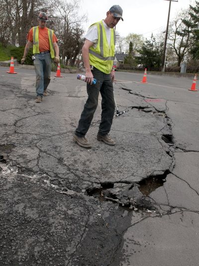 Spokane Water Department workers Brian Strange, in back and Lance Hudkins assess a water main break at Boone Avenue at Summit in West Central. 
  (Colin Mulvany / The Spokesman-Review)