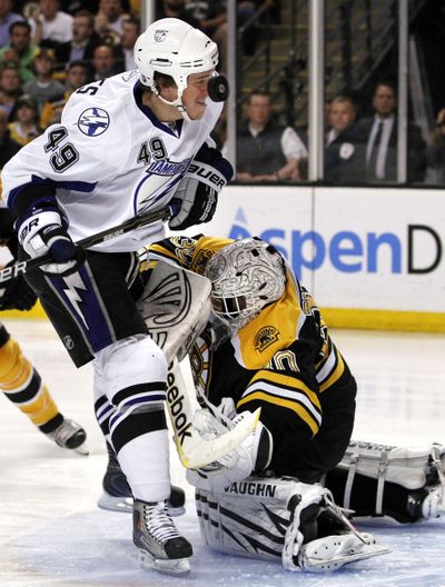 The puck flies by the nose of Tampa Bay Lightning center Blair Jones, left, after a save by Boston Bruins goalie Tim Thomas. (Associated Press)