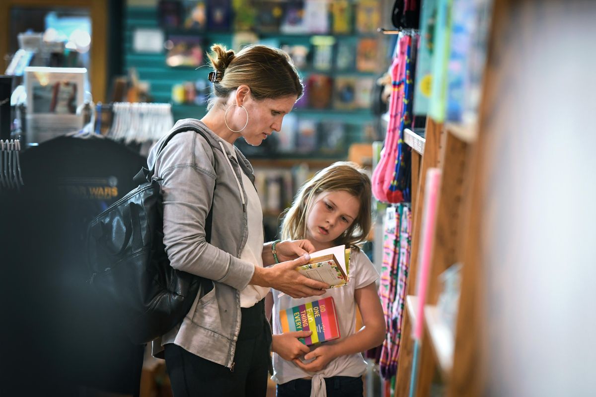 Lisa Tollett, and her daughter, Emma, 7, of Cheney, search the shelves at Auntie’s Book Store, Wednesday, June 5, 2019. in downtown Spokane. (Dan Pelle / The Spokesman-Review)