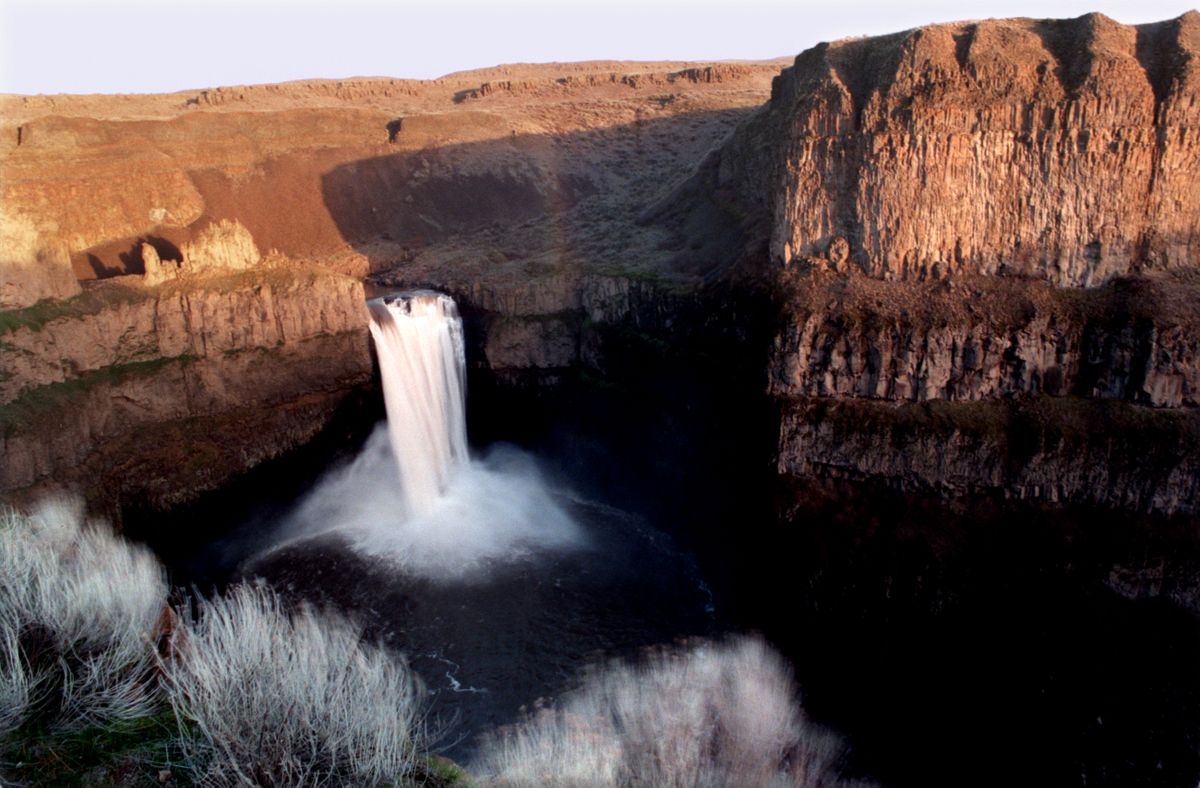This file photo of Palouse Falls shows the green tongue of water at the top left that Tyler Bradt paddled over in his record-breaking kayak decent on April 21, 2009.  The feat raises the question of of the falls