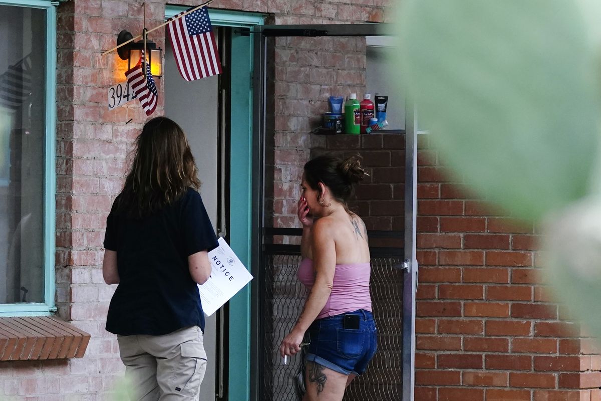 Pima County Constable Kristen Randall, left, speaks to a rental resident on Sept. 24 in Tucson, Ariz., letting her know about an eviction notice.  (Ross D. Franklin)