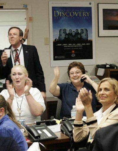 
NASA officials cheer at Kennedy Space Center, in Cape Canaveral, Fla., while watching a video monitor as Discovery touches down in California. 
 (Associated Press / The Spokesman-Review)