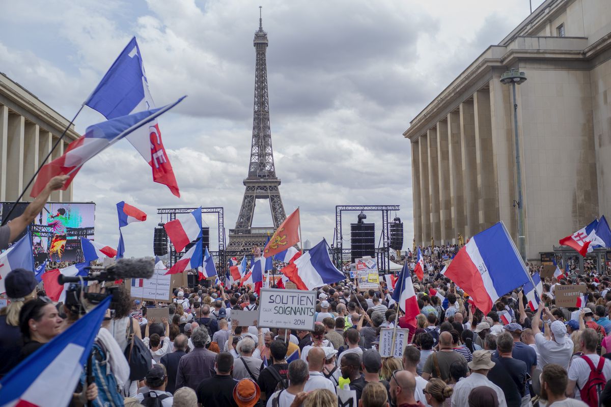 Thousands of protesters gather at Place Trocadero near the Eiffel Tower attend a demonstration in Paris, France, Saturday July 24, 2021, against the COVID-19 pass which grants vaccinated individuals greater ease of access to venues.  (Rafael Yaghobzadeh)