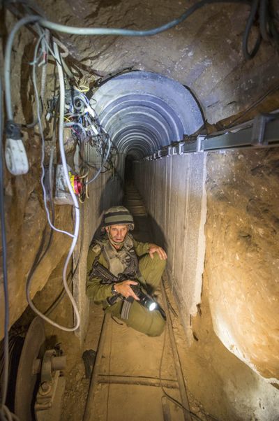 An Israeli army officer gives journalists a tour Friday of a tunnel allegedly used by Palestinian militants for cross-border attacks at the Israel-Gaza Border. (Associated Press)