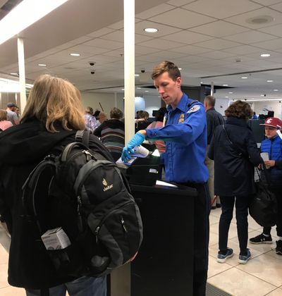 A TSA Officer checks passenger’s travel documents at Spokane International Airport. (Emma Epperly / The Spokesman-Review)