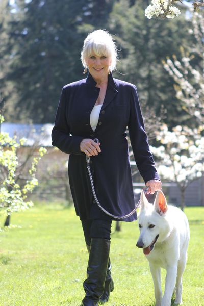 Linda Evans walks her dog, Alexie, on her property in Rainier, Wash.