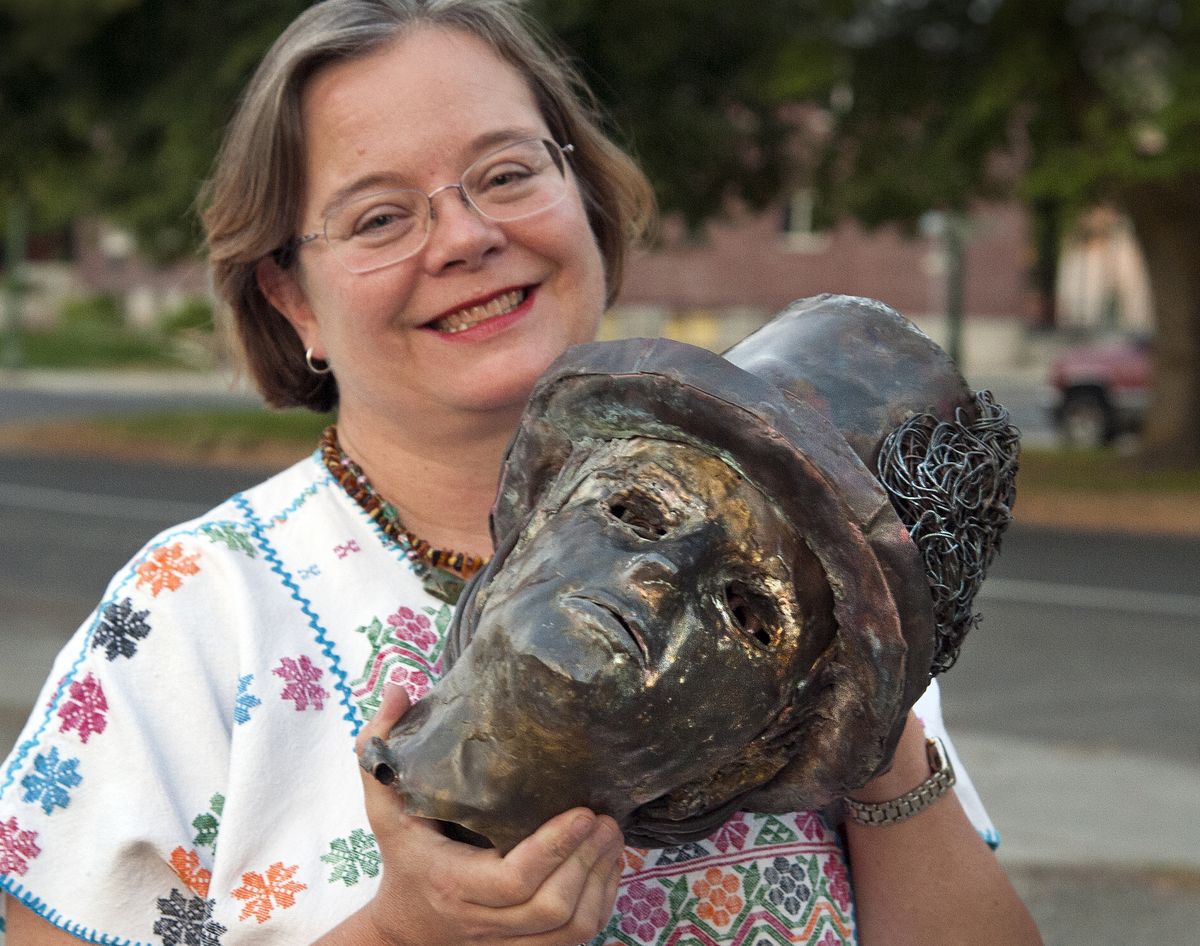 Karen Mobley, program contractor for Spokane Arts, secures the missing statue head Wednesday evening in downtown Spokane.