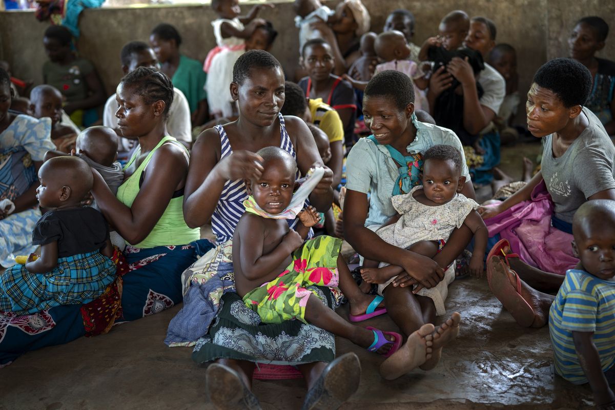 FILE - In this Wednesday, Dec. 11, 2019 file photo, residents of the Malawi village of Tomali wait to have their young children become test subjects for the world