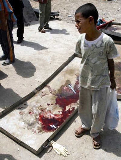 
A boy weeps over a blood- stained stretcher that carried his relative, one of 13 people killed Sunday in mortar attacks in eastern  Baghdad. Associated Press
 (Associated Press / The Spokesman-Review)