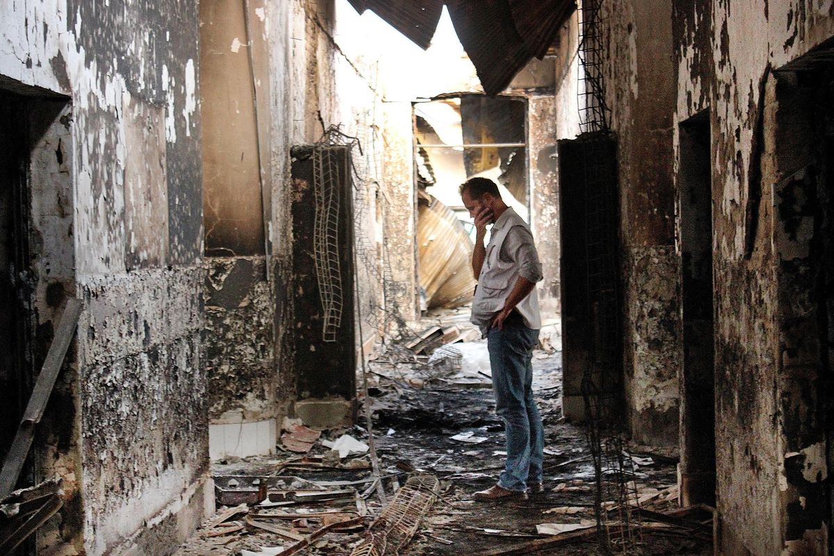 In this Oct. 16, 2015, file photo, an employee of Doctors Without Borders, MSF, walks inside the charred remains of the organization’s hospital after it was hit by a U.S. airstrike in Kunduz, Afghanistan. (Najim Rahim / AP)