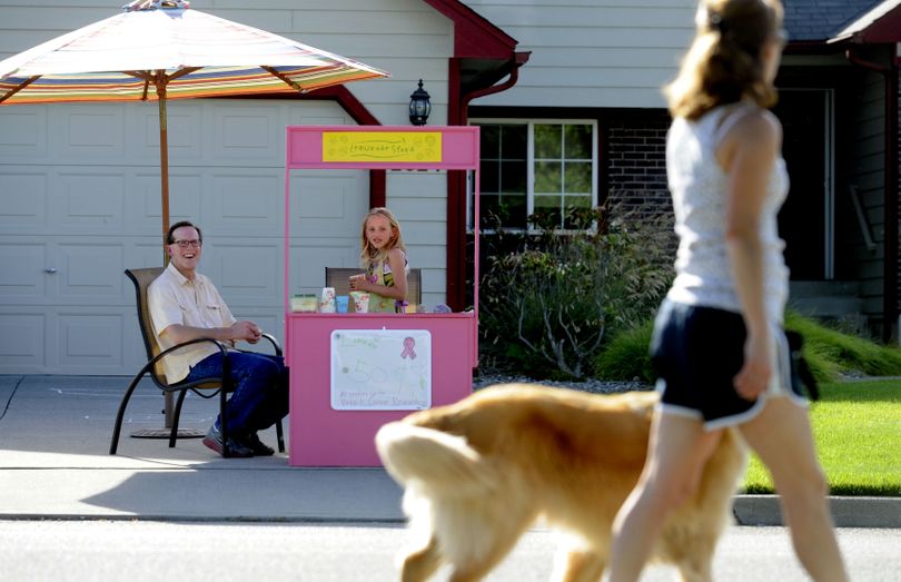 Eight-year-old Lekseea Givens, with her grandfather, Bryan Vanhoff, waits for customers at her lemonade stand in Spokane Valley on June 27. All proceeds go to the Susan G. Komen Foundation. (Kathy Plonka)