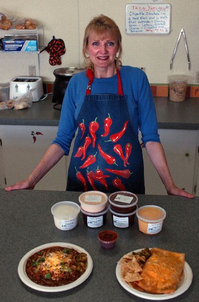 
P.J. Burgess-Derrick displays a menu item, called a Cow Pie, left,  and the grande burrito, at her Tex-Mex restaurant,  Chile Headz in Argonne Plaza.  She also makes  various sauces. 
 (Liz Kishimoto / The Spokesman-Review)