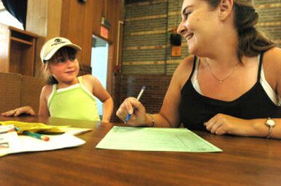 
Megan Krisher, 7, talks with her mother, Tricia Krisher, as they register Megan for second grade at Borah Elementary in Coeur d'Alene on Tuesday, the first day of registration for public school children  in the region. Registration for high schools begins Monday. 
 (Jesse Tinsley / The Spokesman-Review)