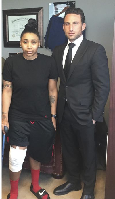 In this April 2016 photo provided by the law office of Lipsig, Shapey, Manus & Moverman P.C., Marc Eli Freund stands next to his client Katrina Williams at the law firm’s offices in New York, as she recovers from injuries she said says she got from an exploding e-cigarette. (Lipsig, Shapey, Manus & Moverman P.C. / Associated Press)
