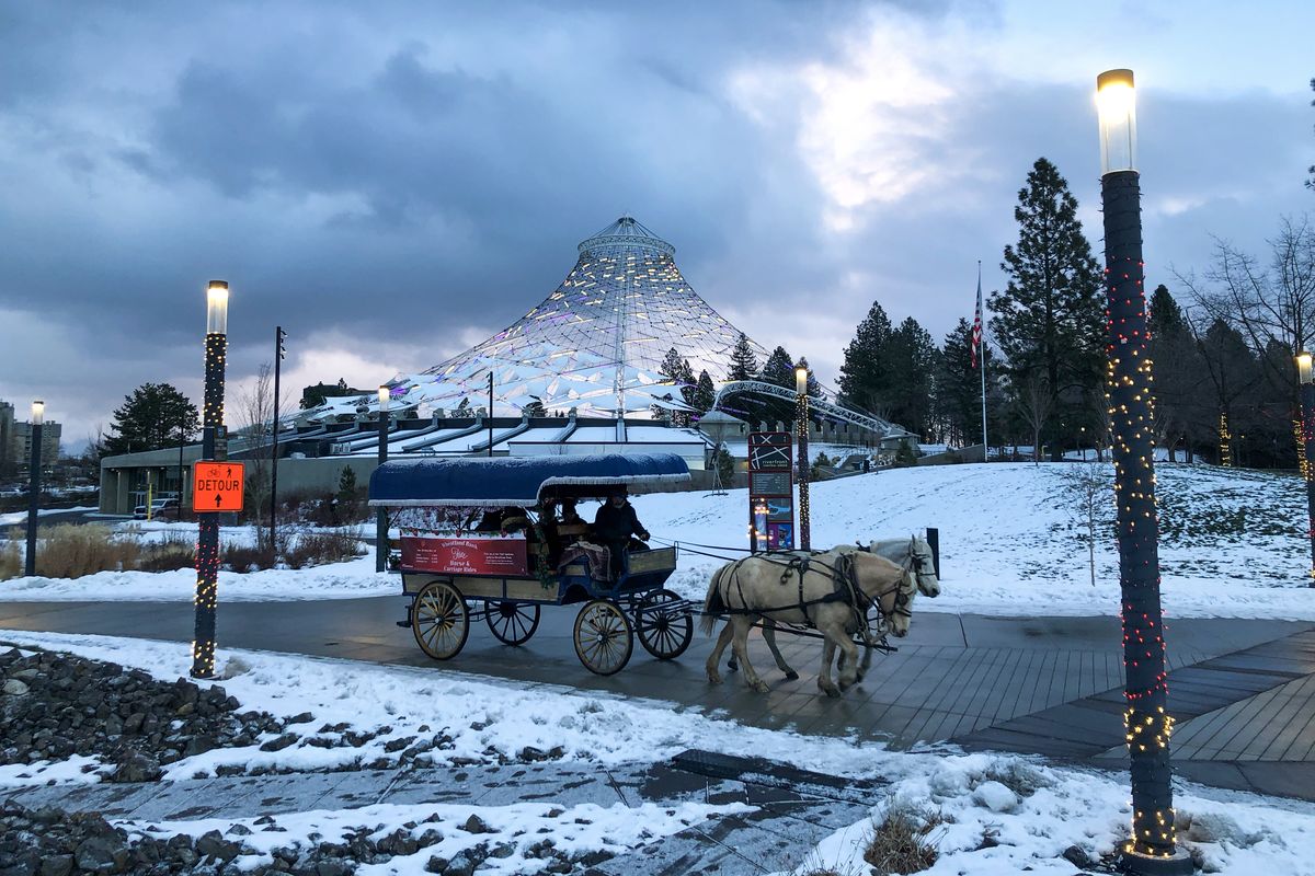 A horse-drawn carriage moves past the Pavilion in Riverfront Park Sunday, Dec. 26, 2021. Free rides were sponsored by Wheatland Bank over the weekend and riders had to have reservations made online.  (Jesse Tinsley/THE SPOKESMAN-REVIEW)