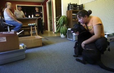 
 Katrina Sawhill, right, bonds with a young female Lab that her family is thinking of adopting, in the lobby of the new Coeur d'Alene Animal Shelter. Her grandfather, Robert Sawhill, and brother, Jeremy Sawhill, talk with manager Debi Slater. 
 (Liz Kishimoto / The Spokesman-Review)