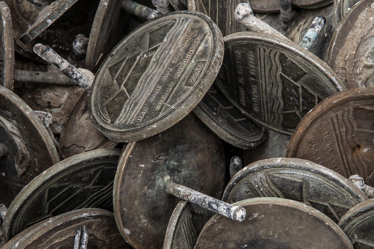 Some of the hundreds of Centennial Trail medallions stolen, or damaged are photographed in Spokane on Wednesday, June 5, 2019. The medallions were purchased to commemorate loved ones, honor special events and celebrate accomplishments. (Kathy Plonka / The Spokesman-Review)