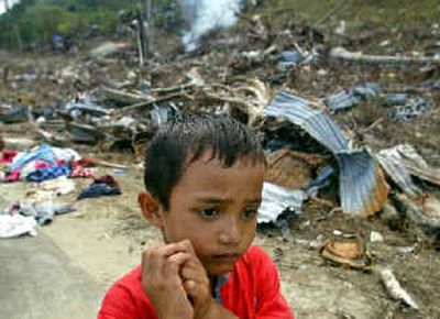 
A boy walks near destroyed homes in the battered town of Calang, Aceh province, on Saturday. 
 (Associated Press / The Spokesman-Review)