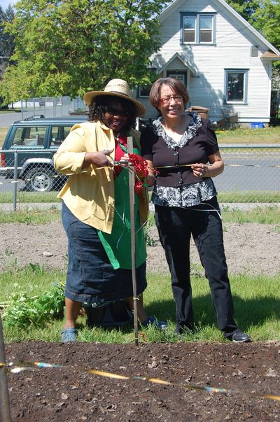 From left, Andrea Blake Hubbard and Una McDowell, members of My Sister’s Temple, cut the ribbon on their new garden bed at the East Central Community Garden. Courtesy of Pat Munts (Courtesy of Pat Munts)