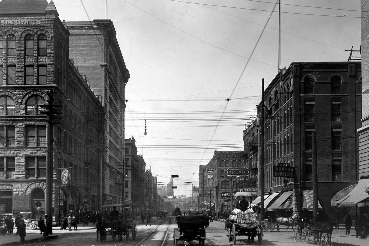 1908: This photograph looks west from North Washington Street, showing an impressive canyon of tall buildings, including the newly completed August Paulsen building, second from left.