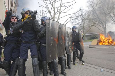 Riot police officers approach anti-NATO activists who set fire to a hotel near the Europe Bridge, east of Strasbourg, France, on Saturday, during NATO’s 60th-anniversary summit.  (Associated Press / The Spokesman-Review)