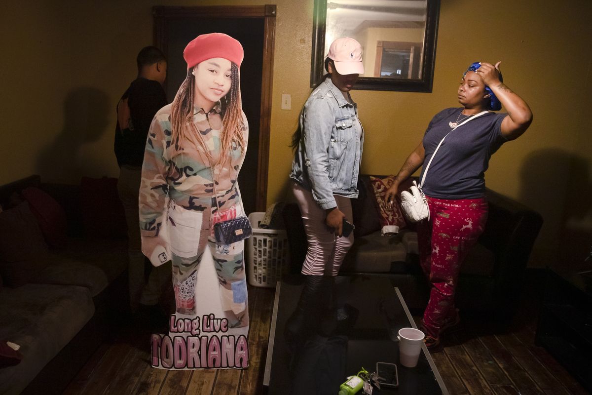 A cutout of Todriana Peters stands in her living room with her cousin Brione Rogers and mother Katrina Lambert in New Orleans, Thursday, July 8, 2021. Twelve-year-old Todriana Peters was shot and killed outside a graduation party on Memorial Day Weekend in the Lower 9th Ward neighborhood. Homicide rates in many American cities have continued to rise although not as precipitously as the double-digit jumps seen in 2020 and still below the violence of the mid-90s. (Sophia Germer)
