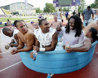 
Party time, like this soak after a hot practice last week, is over at Husky camp. 
 (File/Associated Press / The Spokesman-Review)