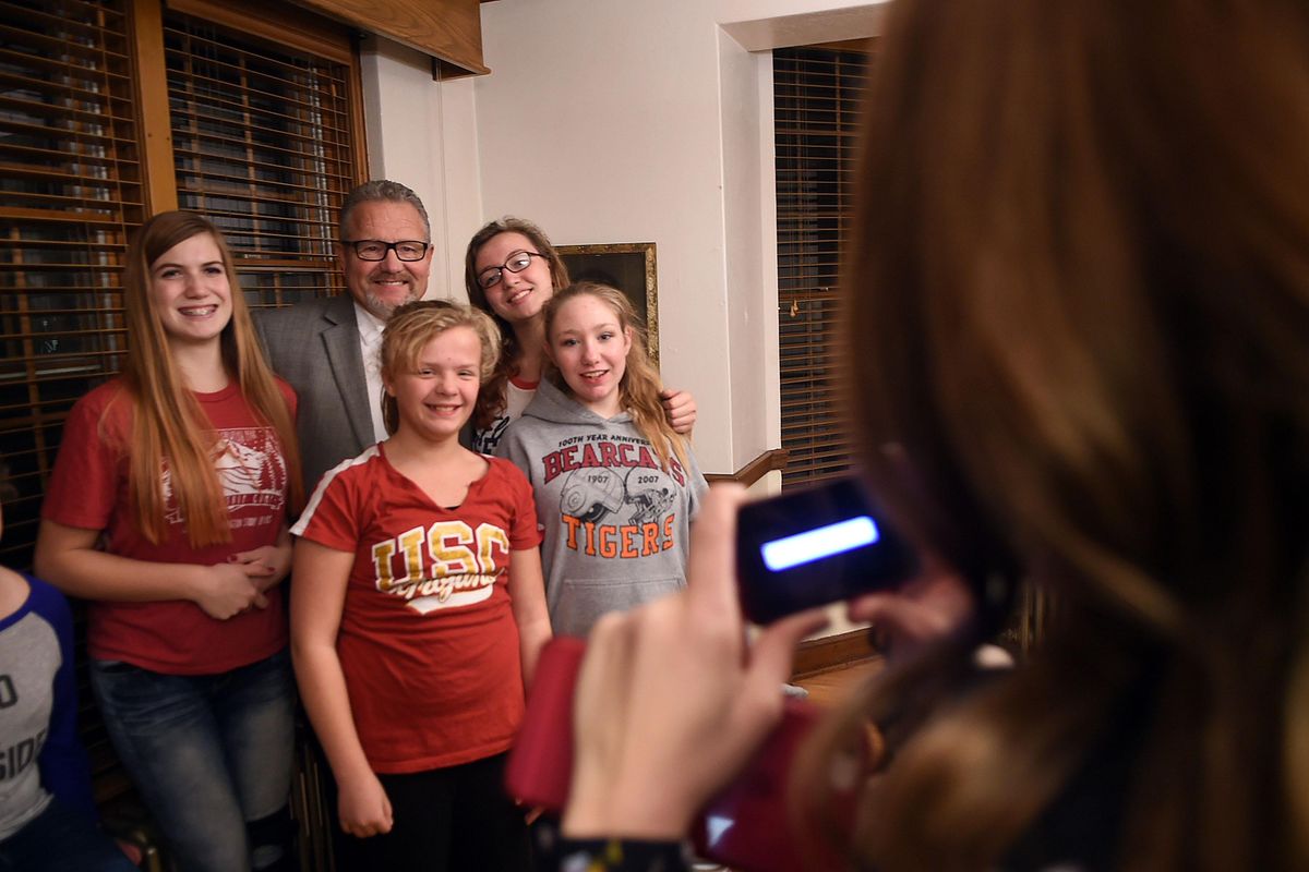 Hutton Settlement Children’s Home Executive Director Mike Butler, center, poses for a picture with current residents, from left, Samantha, Alexee, Gabby and Shiann during his retirement party on Monday, Nov. 14, 2016. (Kathy Plonka / The Spokesman-Review)