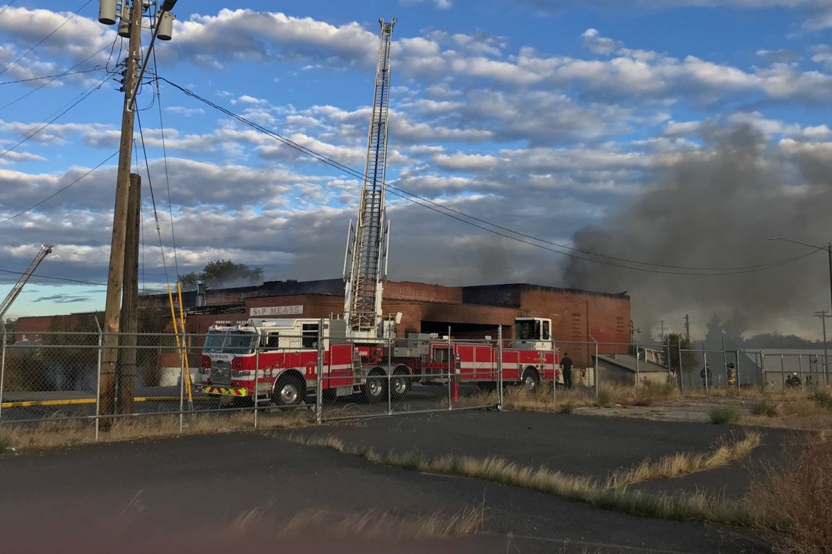 A fire at the abandoned former S&P Meats warehouse at 801 N. Regal Street burned through the night Sunday and into Monday morning.   (Liz Kishimoto / The Spokesman-Review)