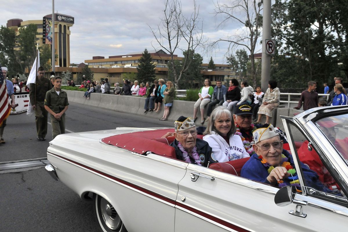 Pearl Harbor survivors John S. Kennedy, back seat, and Charles Boyer, front seat, ride in a convertible Saturday, May 18, 2013, during the annual Lilac Festival Armed Forces Torchlight Parade in downtown Spokane. (Jesse Tinsley / The Spokesman-Review)