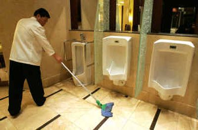 
A Chinese worker cleans up a toilet Wednesday at the hotel where the 2004 World Toilet Summit is being held in Beijing. 
 (Associated Press / The Spokesman-Review)